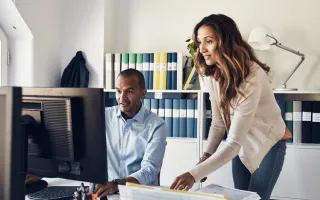 Man and woman looking at something on the computer with interest