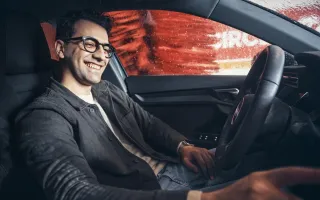 Man smiling in his car during car wash